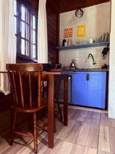 a kitchen with a wooden table and a sink at Recanto do Zeca Morretes in Morretes