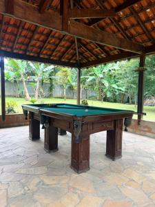 a pool table in a patio with awning at Recanto do Zeca Morretes in Morretes