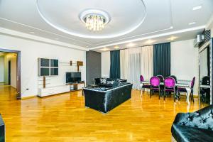 a living room with a couch and a table and chairs at Kolorit Modern Apartment in Baku
