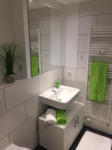 ein weißes Badezimmer mit einem Waschbecken und einem Spiegel in der Unterkunft Boardinghouse Paderborn in Paderborn