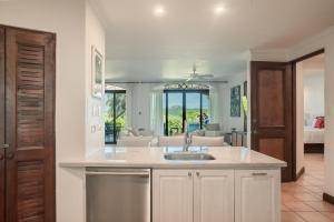 a kitchen with a sink and a living room at Spacious 4BR Condo with Partial Ocean View - Bougainvillea - Reserva Conchal in Playa Conchal