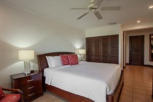 a bedroom with a bed and a ceiling fan at Spacious 4BR Condo with Partial Ocean View - Bougainvillea - Reserva Conchal in Playa Conchal