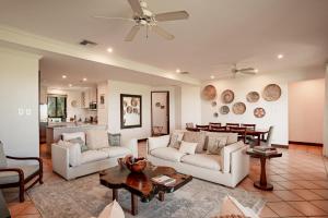 a living room with two white couches and a table at Spacious 4BR Condo with Partial Ocean View - Bougainvillea - Reserva Conchal in Playa Conchal +47 photos