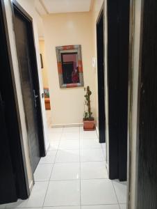 a hallway with black doors and a white tile floor at الصخيرات in Skhirat