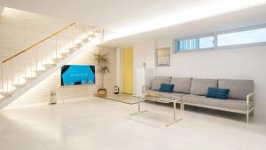 a living room with a couch and a tv at Samcheok Migaloo Pool Villa Pension in Samcheok