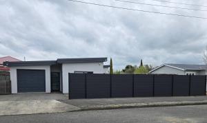 a house with a black fence and a garage at De Vine Martinborough #14a in Martinborough