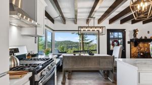 a kitchen with a stove and a large window at Emerald Overlook by AvantStay in Lake Arrowhead