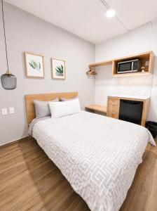 a bedroom with a bed and a microwave on the wall at Aloja Rentals Mexico in Mexico City