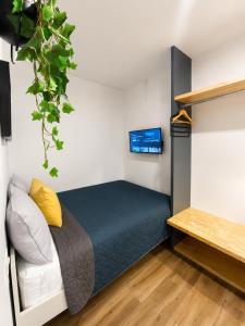 a bedroom with a bed and a tv on the wall at Aloja Rentals Mexico in Mexico City