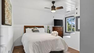 a white bedroom with a bed and a ceiling fan at Emerald Overlook by AvantStay in Lake Arrowhead +33 photos