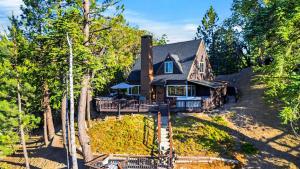 a house on a hill with trees in front of it at Emerald Overlook by AvantStay in Lake Arrowhead
