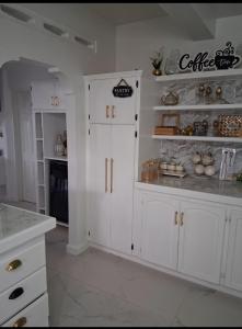 a white kitchen with white cabinets and a counter at Nyack's Palace And Boutique in Beaulieu