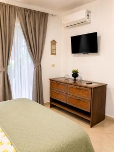 a bedroom with a bed and a dresser with a television at Comfort Room 3 Adults Only in La Laguna