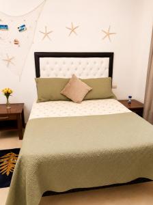 a bedroom with a bed with a green blanket and pillows at Comfort Room 3 Adults Only in La Laguna