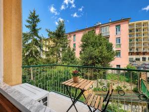 a balcony with a wooden table and chairs and a building at Interi Appartamenti in Centro - Holiday & Wi-Fi Ultra in Campobasso