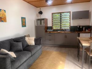 a living room with a couch and a kitchen at Fare Vi in Puahua +23 photos