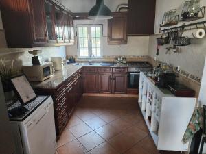 a kitchen with wooden cabinets and a white appliances at Quinta Do Pinheirão in Coruche
