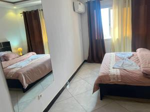 a small bedroom with two beds and a mirror at Adja Adama sow in Dakar