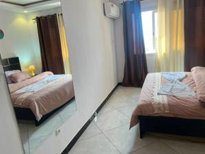 a bedroom with two beds and a mirror at Adja Adama sow in Dakar