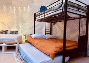 a bedroom with two bunk beds with an orange blanket at The Perch Glamping by Rafting in Cosby