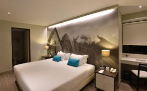 a hotel room with a large white bed with blue pillows at Mariel Hotel Boutique in Lima +47 photos