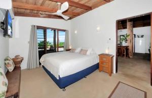 a bedroom with a bed and a ceiling fan at Boonooloo on Absolute Beachfront in Newell Beach