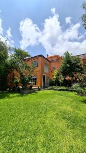 a building with a grassy yard in front of it at Suites Santo Domingo in San Miguel de Allende
