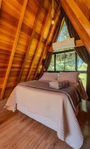 a bed in a room with a wooden ceiling at Cabana com banheira in Gramado +49 photos