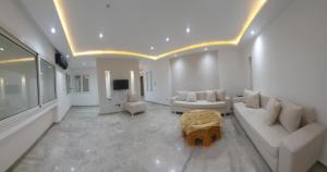 a living room with a couch and a tv at Hammamet villa Bleu in Hammamet