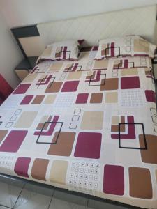 a bed with a comforter and pillows on it at Gite des îles in Sainte-Rose