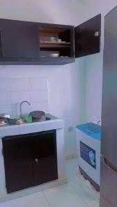 a small kitchen with a sink and a stove at Résidence keur Saloum in Thiès