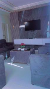 a living room with a couch and a tv at Résidence keur Saloum in Thiès