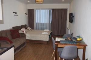 een woonkamer met een bank en een tafel bij New Gudauri Studio 222 in Goedaoeri