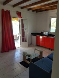 a kitchen with a couch and a table in a room at Gite des îles in Sainte-Rose