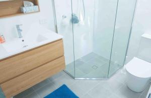 a bathroom with a shower and a toilet and a sink at Glistening Waters in Tathra +7 photos