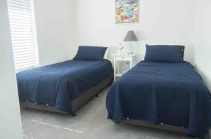 two beds sitting next to each other in a bedroom at Glistening Waters in Tathra