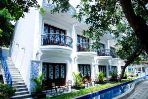 a white building with stairs and balconies on it at Le MIAMI RESORT in Pondicherry