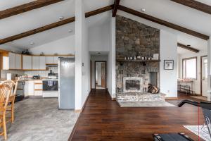a kitchen and living room with a stone fireplace at Rustic Mountain view Cabin 5 mins to Ski Area! in Windham