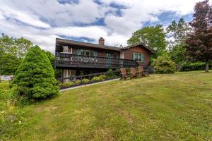 a house with a deck and benches in the yard at Rustic Mountain view Cabin 5 mins to Ski Area! in Windham