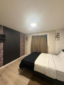 a bedroom with a large bed and a window at Haverims Cozy and Neat Basement in Edmonton