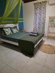 a bedroom with a bed with a green comforter at Bleu Caraïbe in Sainte-Anne +31 photos