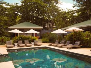 a swimming pool with lounge chairs and umbrellas at The Providence Hotel Boutique - Adults Only in San Andrés