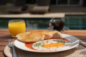 a plate of eggs and toast and a glass of orange juice at The Providence Hotel Boutique - Adults Only in San Andrés