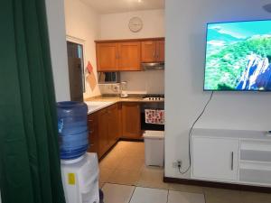 eine Küche mit einem Fernseher an der Wand und eine Küche mit einem Gerät in der Unterkunft Don César in Las Terrenas