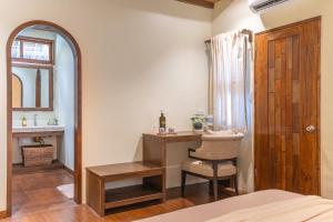 a bedroom with a desk and a chair and a mirror at Camanolo Homestay in General Luna +27 photos
