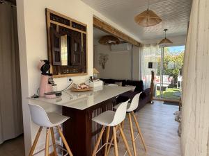 a kitchen with a counter and stools in a room at L Effet Mer Cocon climatisé avec terrasse et jardin privés Piscine in Audenge
