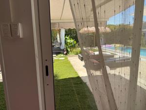 a door to a house with a view of a yard at L Effet Mer Cocon climatisé avec terrasse et jardin privés Piscine in Audenge
