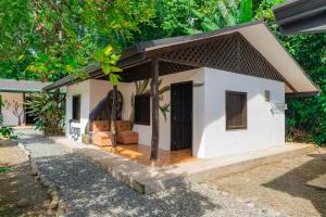 a small white house with a brown roof at Sloth Bungalows Manzanillo in Manzanillo