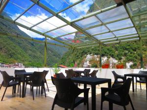 a restaurant with tables and chairs and a view of a mountain at Terraza de Luna in Machu Picchu