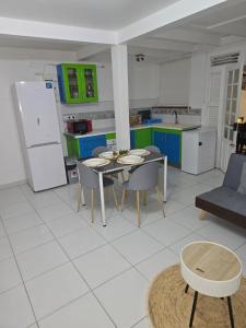 a kitchen with a table and chairs and a refrigerator at Bleu Caraïbe in Sainte-Anne